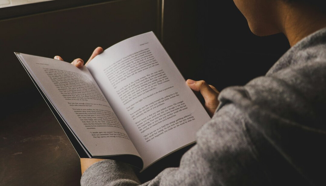 person reading book in morning light