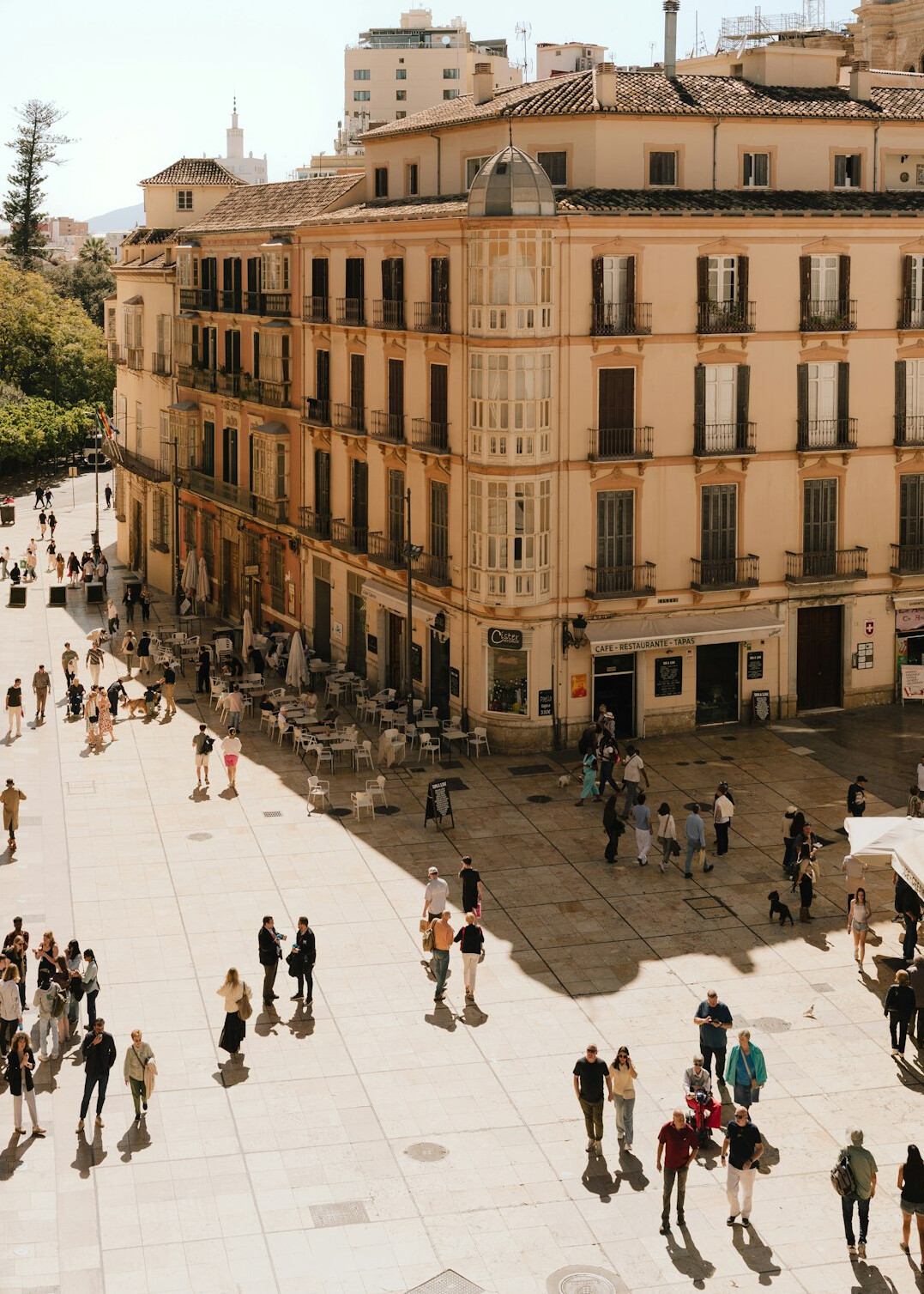 Anonymous crowd of people seen from a distance walking through a plaza